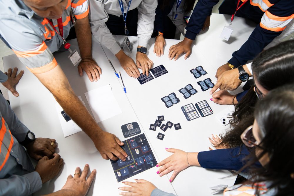 Participantes reunidos em volta da mesa durante a dinâmica Blackout