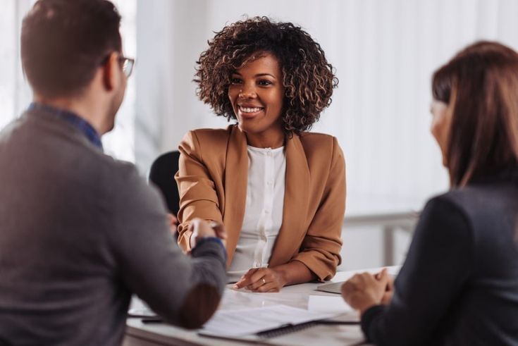 Candidata cumprimentando recrutadores em entrevista de recrutamento e seleção